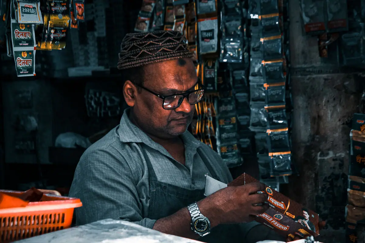 A shopkeeper arranging products in his store