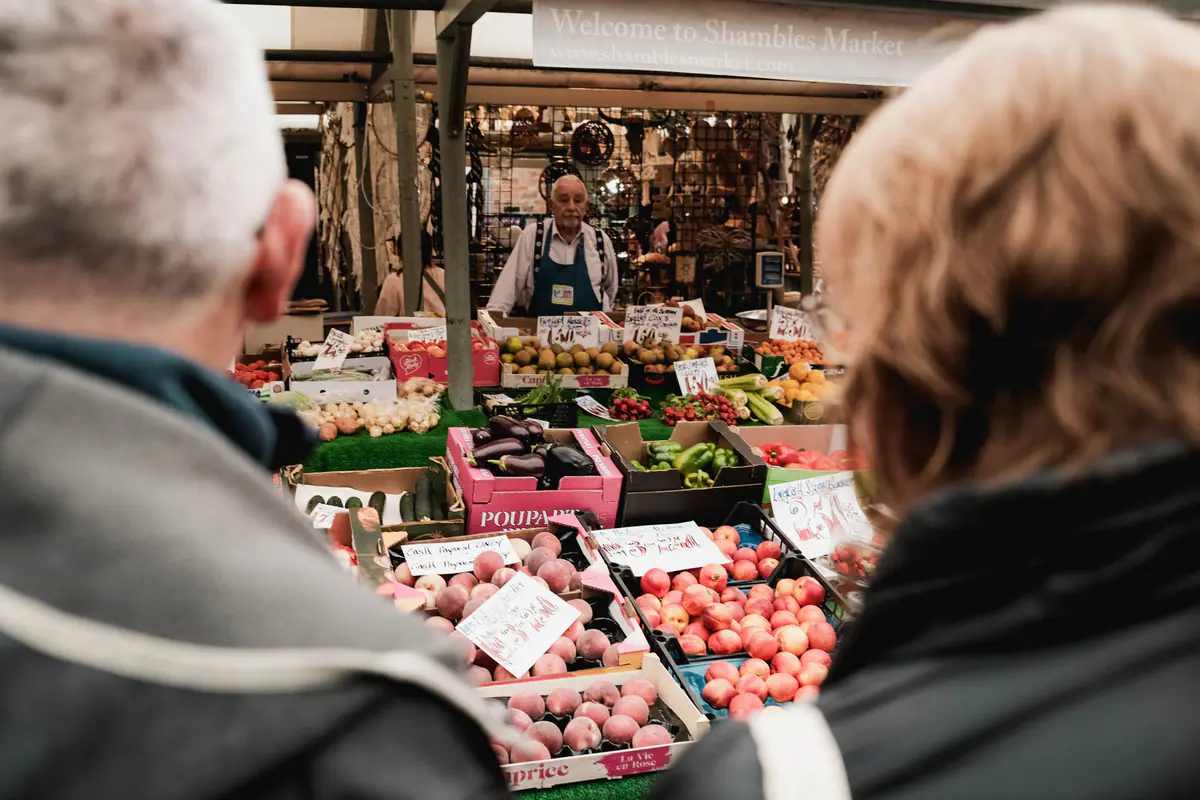 Shoppers browsing colourful stalls at a bustling British market