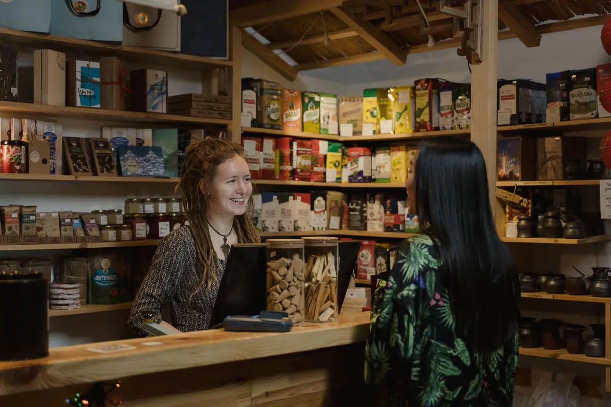 A shopkeeper helping a customer in a well-stocked store