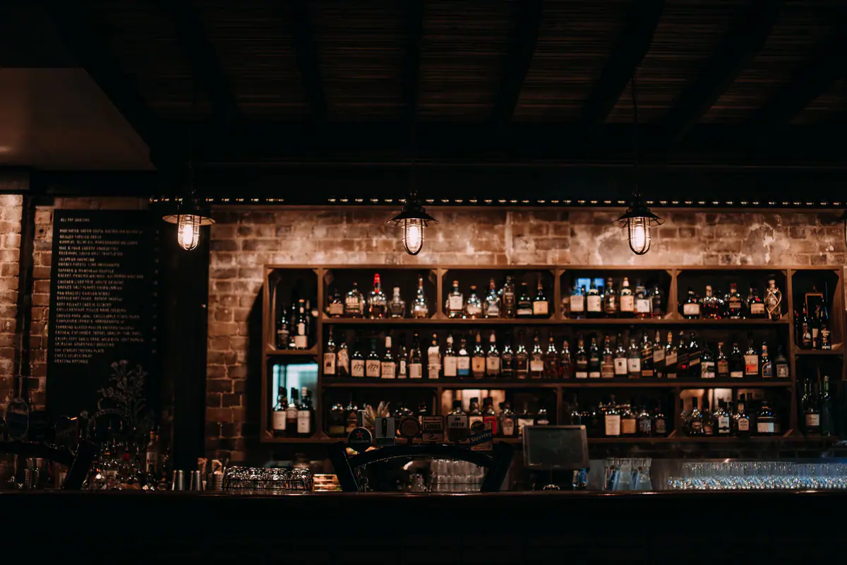 The warmly lit back bar of a busy restaurant